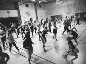 Zumbagrupp som dansar i en idrottshall